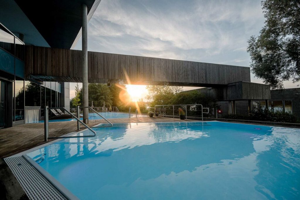 Abendstimmung am Außenpool der Fontane Therme bei Sonnenuntergang.